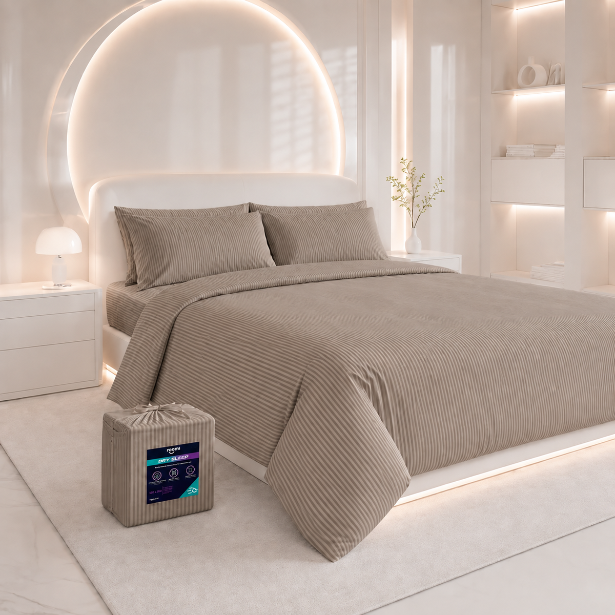 סט מצעים “Roomi” מסדרת “Dry Sleep” מבד ג'רסי פסים בצבע חאקי על מיטה מודרנית; סט תואם ארוז מונח על הרצפה.