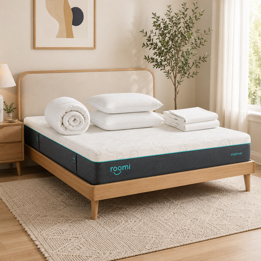 חדר שינה מודרני עם חבילת “Roomi Explorer Cloud” · הסט המפנק, מצעים לבנים, כריות קצף זיכרון ומגבות על שטיח בצבע בז'.