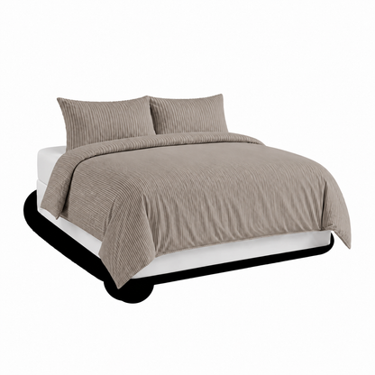 מיטה מסודרת עם סט המצעים “Dry Sleep” של Roomi, העשוי מג'רסי פסים בצבע חאקי, ושתי כריות תואמות על רקע לבן.